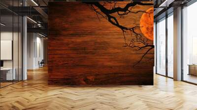 Silhouette of a bare tree branch against a blood orange moon on a wood background Wall mural