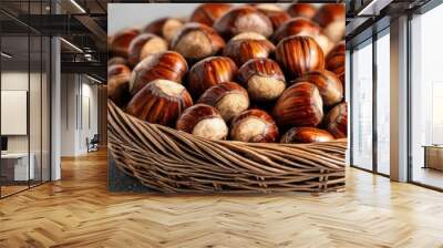 A close-up of fresh hazelnuts in a woven basket, showcasing their natural texture and color on a rustic background. Wall mural