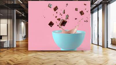 cocoa cereal falling into blue bowl with splashing milk on pink background. Wall mural