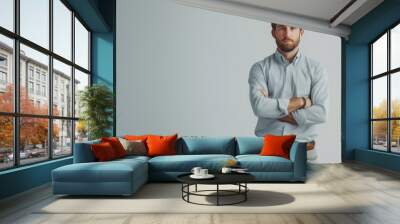 A confident man standing tall against a seamless white backdrop Wall mural