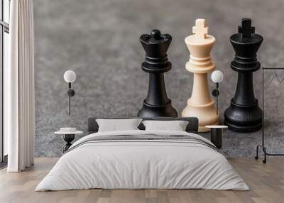 Chess pieces symbolize strategy and competition, showcasing black king, white king, and black rook on textured surface. Their contrasting colors represent duality of wealth and longevity in game Wall mural