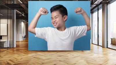 Strong healthy Asian boy shows his muscle Wall mural