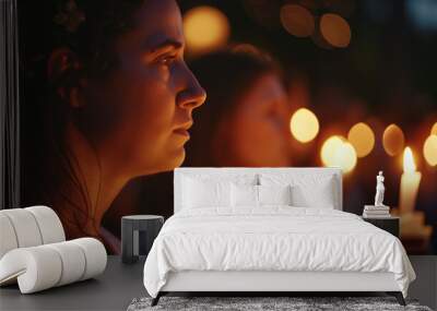 Serene young woman holding candle at vigil with warm bokeh lights Wall mural