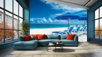 A beach scene with two blue lounge chairs and a umbrella. The chairs are facing the ocean and the umbrella is providing shade.
 Wall mural