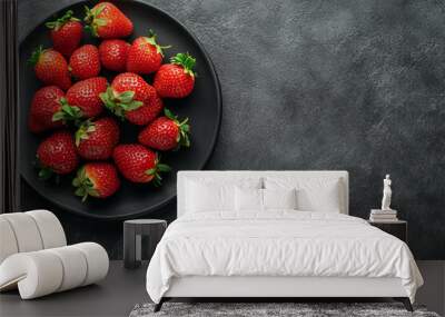 A plate of fresh strawberries on a dark background, viewed from above. Wall mural