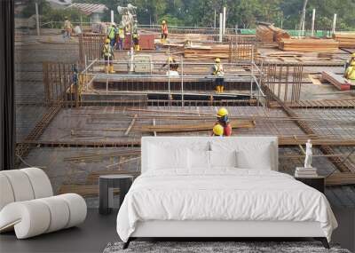 Construction workers fabricating steel reinforcement bar at the construction site. The reinforcement bar was tied together using tiny wire.     Wall mural