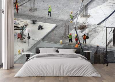 KUALA LUMPUR, MALAYSIA -AUGUST 27, 2018: Concreting work by construction workers at the construction site. Heavy machinery used to carry wet concrete to the pouring location.  Wall mural