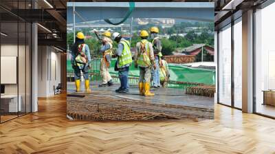 MALACCA, MALAYSIA -MAY 13, 2016: Construction workers working at the construction site at Malacca, Malaysia during daytime. They are wearing proper safety gear so ensure they are safe working.   Wall mural