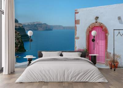 The picturesque and charming island. Beautiful pink wooden door with flowers on the white wall  Wall mural