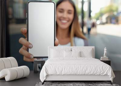 Close-up, Happy beautiful woman showing white smartphone Wall mural