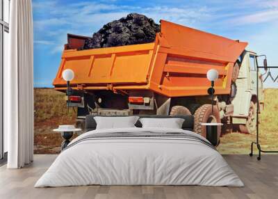 Coal in the back of the orange truck. Coal mining. Coal delivery Wall mural