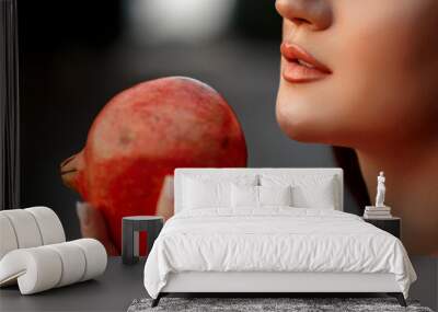 close-up portrait of a young beautiful girl with a pomegranate in her hands. shallow DOF. selective focus. Wall mural