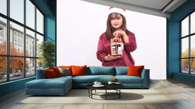 beautiful young woman southeast asia thin smile lifting gift hamper at christmas wearing santa claus hat modern red shirt outfit white background for promotion and advertising Wall mural