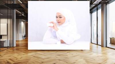 expression Beautiful elegant young hijab woman asia looking at camera hand holding cosmetic cream on right chin for daily skin care routine needs on white background. Facial treatment, Perfect skin Wall mural