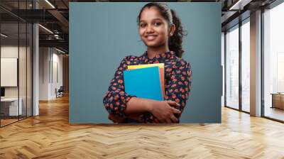 Happy young girl holding note books in her hand Wall mural