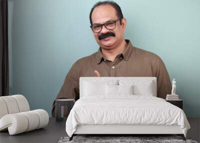 Portrait of a middle aged man of Indian ethnicity shows Ok gesture Wall mural