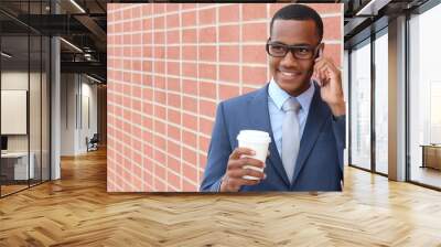 African businessman walking with coffee on the phone Wall mural