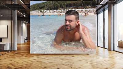 Attractive bearded shirtless man at the beach  Wall mural