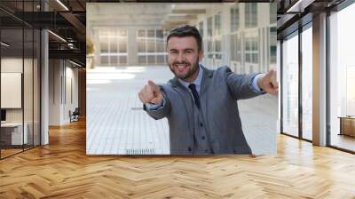 Confident businessman pointing at camera  Wall mural