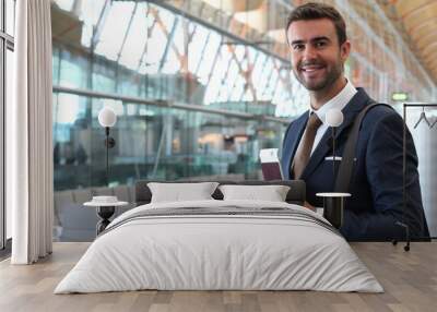 Handsome businessman smiling at the airport with space for copy Wall mural