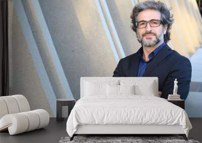 Mature urban business man with specs crossing his arms  Wall mural