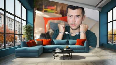 Young hug wearing handcuffs at home Wall mural