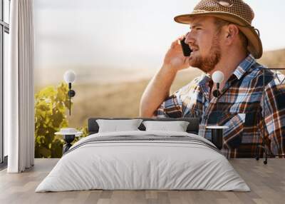 Farmer, man and phone call at vineyard, conversation and contact for deal, negotiation and mock up space in summer. Person, agriculture and smartphone with sustainability, chat and listen in Spain Wall mural