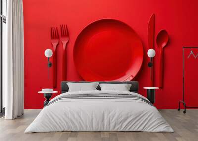 A minimalistic dining concept is illustrated with a top-down view of a red round plate and cutlery on a red surface. The table is set for dinner, forming an abstract food background with utensils. Wall mural