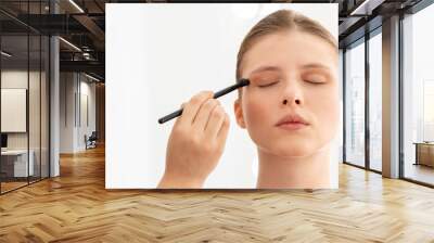 Make up artist applies eye shadows. Hand of make-up master, painting model eyes Wall mural