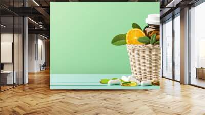 A vibrant display of vitamins and natural products in a wicker basket with orange slices and greenery on a calming backdrop. Wall mural