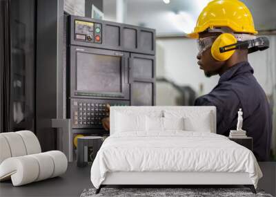 Portrait of African American mechanic engineer worker wearing safety equipment beside the automatic lathe machine in manufacturing factory Wall mural