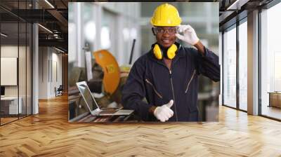 Portrait of African American mechanic engineer worker wearing safety equipment beside the sawing machine in manufacturing factory Wall mural