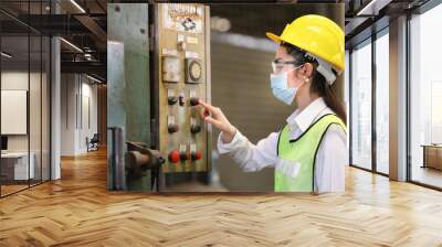 Portrait of woman Asian mechanic engineer worker wearing safety equipment beside the switch of electric machine system in manufacturing factory Wall mural