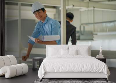 Asian engineer wearing hard hat talking with business man in formal suit in the factory Wall mural