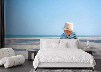 Asian two year old toddler boy playing with beach toys on beach. Wall mural