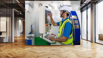 Mechanical technician operative entering data in cnc milling cutting machine at factory at tool workshop in metal machining industry. Wall mural