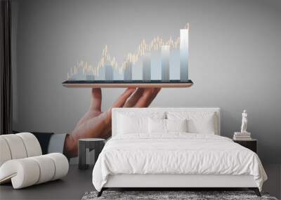 Hand of businessman holding tablet analysis stock market graph growth and increase of chart positive indicators. Hand holding tablet show stock chart on light gray background Wall mural