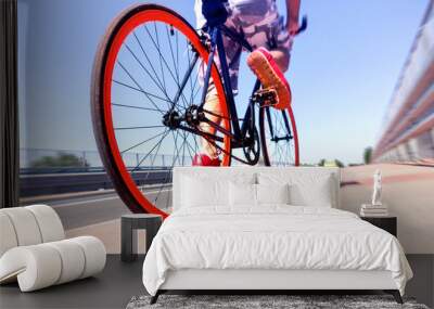 Man cycling on sport bike - Bicycle wheels and road perspective with cyclist riding  blue summer sky background - Concept of alternative transportation  environmental friendly   Wall mural