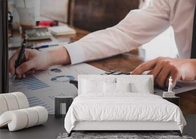 businessman hand using calculator Calculating bonus(Or other compensation) to employees to increase productivity.Writing paper on desk.Selective Focus Wall mural