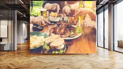 Close up hand, eating.Group Of People Dining Concept,With  Chicken roasting,salad,French fries on wooden table Wall mural