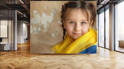 Happy little girl with Ukrainian flag on beige background. Wall mural