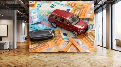 key and red toy car on pile of euro banknotes, buy or sell a car, rent a car or insurance concept Wall mural