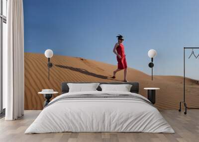 Woman in red dress on sand dunes Wall mural