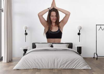 Woman doing yoga in photo studio on isolated white background. Wall mural