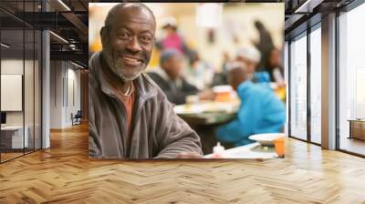 One elderly African-American man sitting in a busy community dining hall, smiling warmly. Soft indoor lighting and blurred background. Horizontal image.

Concept:
social support, elderly happiness, co Wall mural