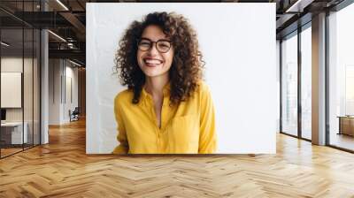 Smiling woman with curly hair and glasses, wearing a yellow shirt, joyful expression, casual fashion, cheerful mood concept Wall mural