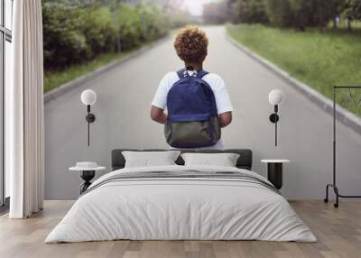 Portrait of the cute african american boy who is going to school with his school  backpack. Student mixed boy on his way to the school. Study for children. Road. Shooting on the july 2018.  Wall mural