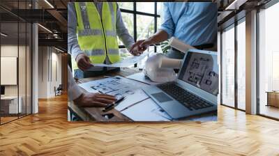 Close up of hands working and brainstorming on paperworks and floor plan drawings about design architectural and engineering for houses and buildings. Wall mural