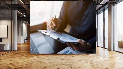 Close up of hands working and calculating on financial and accounting graft and chart in office space. Wall mural