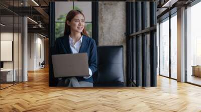 Young business women working and typing on laptop with happy and smile face on office spec. Wall mural